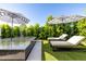 Relaxing pool area with lounge chairs and umbrellas surrounded by lush green landscaping at 3684 E Boot Track Trl, Gilbert, AZ 85296