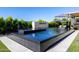 Backyard pool featuring a modern water feature surrounded by lush landscaping at 3684 E Boot Track Trl, Gilbert, AZ 85296