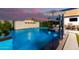 Backyard pool with a built-in fire feature, lounge seating, and manicured landscaping at 3684 E Boot Track Trl, Gilbert, AZ 85296