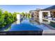 The backyard features a modern outdoor pool with a sleek design, and a covered patio area perfect for lounging and entertaining at 3684 E Boot Track Trl, Gilbert, AZ 85296