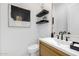 Stylish powder room featuring a wood vanity, black fixtures, and modern decor at 3684 E Boot Track Trl, Gilbert, AZ 85296