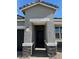 An inviting entrance highlighted by stone accents with a covered entryway to the front door at 38055 W Excussare Way, Maricopa, AZ 85138