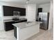 Modern kitchen with stainless steel appliances, granite countertops, and a central island at 38055 W Excussare Way, Maricopa, AZ 85138