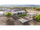 Aerial shot showcases home's outdoor features, including a green lawn, fire pit and covered patio at 3911 N 197Th Ave, Buckeye, AZ 85396