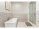 Bathroom featuring a standalone tub and a glass-enclosed shower with decorative tile at 3911 N 197Th Ave, Buckeye, AZ 85396