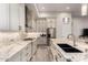 Stylish kitchen features a stainless refrigerator, light-colored cabinetry and stone countertops at 3911 N 197Th Ave, Buckeye, AZ 85396