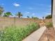 Beautiful backyard featuring a block wall, flowering plants, and a paved walkway under a blue sky at 3932 E Tierra Buena E Ln, Phoenix, AZ 85032