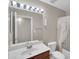 Well-lit bathroom featuring a single sink vanity, large mirror, and a shower with curtain enclosure at 3932 E Tierra Buena E Ln, Phoenix, AZ 85032