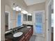 Bathroom with dual sinks, granite counters, vanity, mirrors, and a door to outside at 3932 E Tierra Buena E Ln, Phoenix, AZ 85032