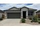 Charming single-story home features a two-car garage, desert landscaping, and modern architectural details at 40070 W Venture Rd, Maricopa, AZ 85138
