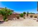 The backyard features a paved patio and desert landscaping with shrubbery and a block fence at 41103 W Rio Bravo Dr, Maricopa, AZ 85138