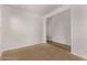 A blank bedroom featuring neutral carpet, white walls, and large doorway to second room at 41103 W Rio Bravo Dr, Maricopa, AZ 85138