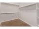 Walk-in closet with carpeted flooring, shelving, and rods for hanging clothes providing ample storage space at 41103 W Rio Bravo Dr, Maricopa, AZ 85138