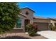 Close up of a single-story home featuring desert landscaping, arched windows, and a two-car garage at 41103 W Rio Bravo Dr, Maricopa, AZ 85138