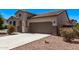 Side view of a one-story home featuring desert landscaping, concrete driveway, and an attached two-car garage at 41103 W Rio Bravo Dr, Maricopa, AZ 85138