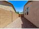 A gravel side yard sits between homes, enclosed by brick walls for privacy at 41103 W Rio Bravo Dr, Maricopa, AZ 85138