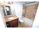 Bright bathroom featuring shower-tub combo with stone-look tile, granite vanity and updated fixtures at 4120 N 78Th St # 116, Scottsdale, AZ 85251