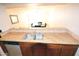 Well-lit kitchen showing sink, stone countertop, and cabinetry at 4120 N 78Th St # 116, Scottsdale, AZ 85251