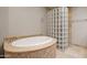 A luxurious bathroom features a jacuzzi tub, glass block wall, and marble countertops at 4226 N 69Th Pl, Scottsdale, AZ 85251