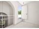 Upstairs hallway featuring modern railing, white walls, and an open back door at 4226 N 69Th Pl, Scottsdale, AZ 85251