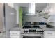 A kitchen with a stainless steel hood over an electric range and barstool seating beyond the counter at 4255 N 68Th Dr, Phoenix, AZ 85033
