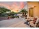 Outdoor patio area with comfortable seating, lush landscaping, mature trees, and beautiful sunset views at 4462 E Dale Ln, Cave Creek, AZ 85331