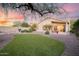 Expansive backyard with artificial turf, rock landscaping, mature trees, and a built-in barbecue area at 4462 E Dale Ln, Cave Creek, AZ 85331