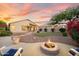 Scenic backyard with a fire pit, mature trees, desert landscaping, artificial turf, and an outdoor patio at 4462 E Dale Ln, Cave Creek, AZ 85331