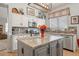 An island with granite countertops and a gray base provides both workspace and additional storage at 4462 E Dale Ln, Cave Creek, AZ 85331