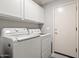 Well-equipped laundry room with white cabinetry and appliances, conveniently located near an exterior door at 4462 E Dale Ln, Cave Creek, AZ 85331