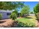 Lush backyard featuring mature trees, a well-maintained lawn, and covered patio at 4626 W Altadena Ave, Glendale, AZ 85304