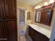 Bathroom features a vanity with marble countertop, dark wood cabinets, and decorative mirror at 4626 W Altadena Ave, Glendale, AZ 85304