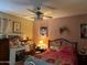 Cozy bedroom featuring a ceiling fan with light kit, vanity with mirror, and a patterned bedspread at 4626 W Altadena Ave, Glendale, AZ 85304