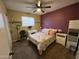 Cozy bedroom with a ceiling fan, floral bedding, and colorful accent wall at 4626 W Altadena Ave, Glendale, AZ 85304