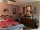 Well-decorated bedroom featuring a wrought iron bed frame and a wooden dresser with a mirror at 4626 W Altadena Ave, Glendale, AZ 85304