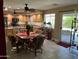 Bright kitchen with a dining area, wooden cabinets, tile flooring, and a sliding glass door to the outside at 4626 W Altadena Ave, Glendale, AZ 85304