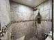 Tiled shower featuring a built-in bench, shower head, niche with a mosaic accent border, and tile floor at 4626 W Altadena Ave, Glendale, AZ 85304