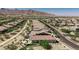 An aerial view of a desert community highlighting the tile rooftops and landscaped yards with mountain views at 4898 N 206Th Ln, Buckeye, AZ 85396
