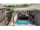 Aerial view of outdoor living space featuring a hot tub, covered patio, swimming pool, seating, and manicured landscaping at 4898 N 206Th Ln, Buckeye, AZ 85396