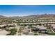 Wide aerial shot of a community boasting mature trees, landscaping, and stunning mountain backdrop at 4898 N 206Th Ln, Buckeye, AZ 85396
