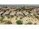 Aerial shot showcases the community with well-maintained homes, mature landscaping, and beautiful mountain views in the distance at 4898 N 206Th Ln, Buckeye, AZ 85396