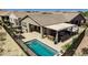 This backyard features a sparkling pool, covered patio with seating, and outdoor dining space for entertaining at 4898 N 206Th Ln, Buckeye, AZ 85396