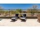 Inviting backyard with lounge chairs, a cozy seating area, mature landscaping, and views of the surrounding neighborhood at 4898 N 206Th Ln, Buckeye, AZ 85396