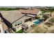 Aerial view of a home's backyard, complete with a pool, covered patio, and outdoor dining set at 4898 N 206Th Ln, Buckeye, AZ 85396