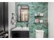 Stylish powder room featuring a unique vanity, decorative mirror, and eye-catching green tile at 4898 N 206Th Ln, Buckeye, AZ 85396