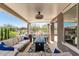 Spacious covered patio with plush seating, a ceiling fan, and views of the landscaped backyard and outdoor space at 4898 N 206Th Ln, Buckeye, AZ 85396