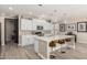 Modern kitchen featuring a large center island, white cabinetry, stainless steel appliances, and bar seating at 4898 N 206Th Ln, Buckeye, AZ 85396