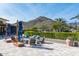 Relaxing outdoor lounge area featuring cozy seating, umbrellas, and mountain views at 4898 N 206Th Ln, Buckeye, AZ 85396