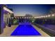 Beautifully illuminated pool and outdoor patio with stylish design elements and serene ambiance under the night sky at 4898 N 206Th Ln, Buckeye, AZ 85396