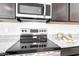 Close-up of the kitchen's stainless steel appliances, including a microwave and stove at 4999 E Umber Rd, San Tan Valley, AZ 85143